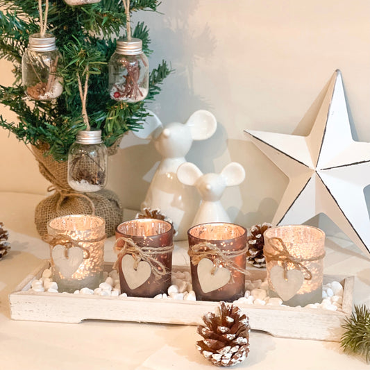 Glass candle holders on wooden tray